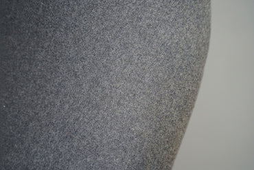 Close-up af lysegrå uldpolstring på Offecct loungestol med elegante detaljer og krom stel.