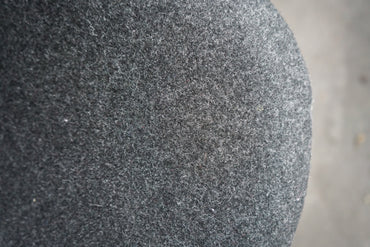 Close-up af mørkegrå uldpolstring på Offecct loungestol med krom stel og moderne detaljer.