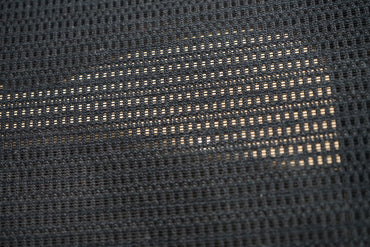 Close-up af Okamura Baron kontorstol med armlæn, der viser mesh-ryg og sædedetaljer.