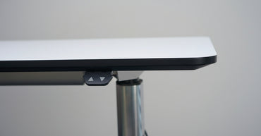 Nærbillede af Paustian A-One hæve sænkebords hvid bordplade og oplukkelig kabelbakke