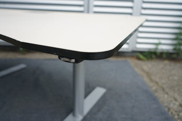 Close-up af lys linoleum bordplade på Paustian hæve-sænkebord 160x90 i beige.