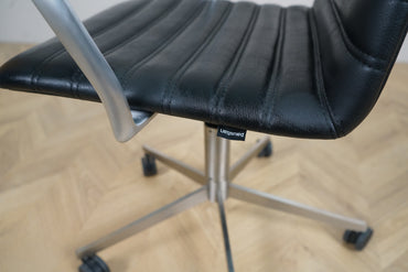 Nærbillede af Paustian Spinal kontorstol i sort læder, der viser den elegante polstring og aluminiumsarmlæn.