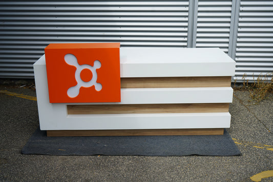 Frontbillede af reception desk 214x80x88 cm i hvid med trædetaljer og orange frontpanel.