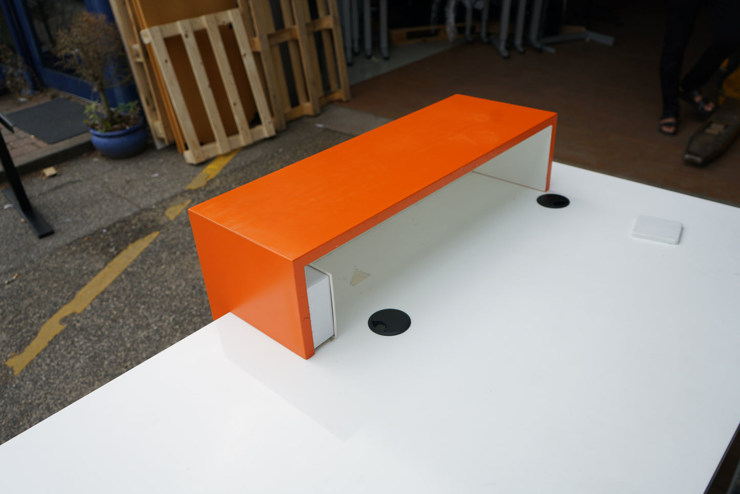 Detaljebillede af orange frontpanel med udskåret design på receptionsbordet.