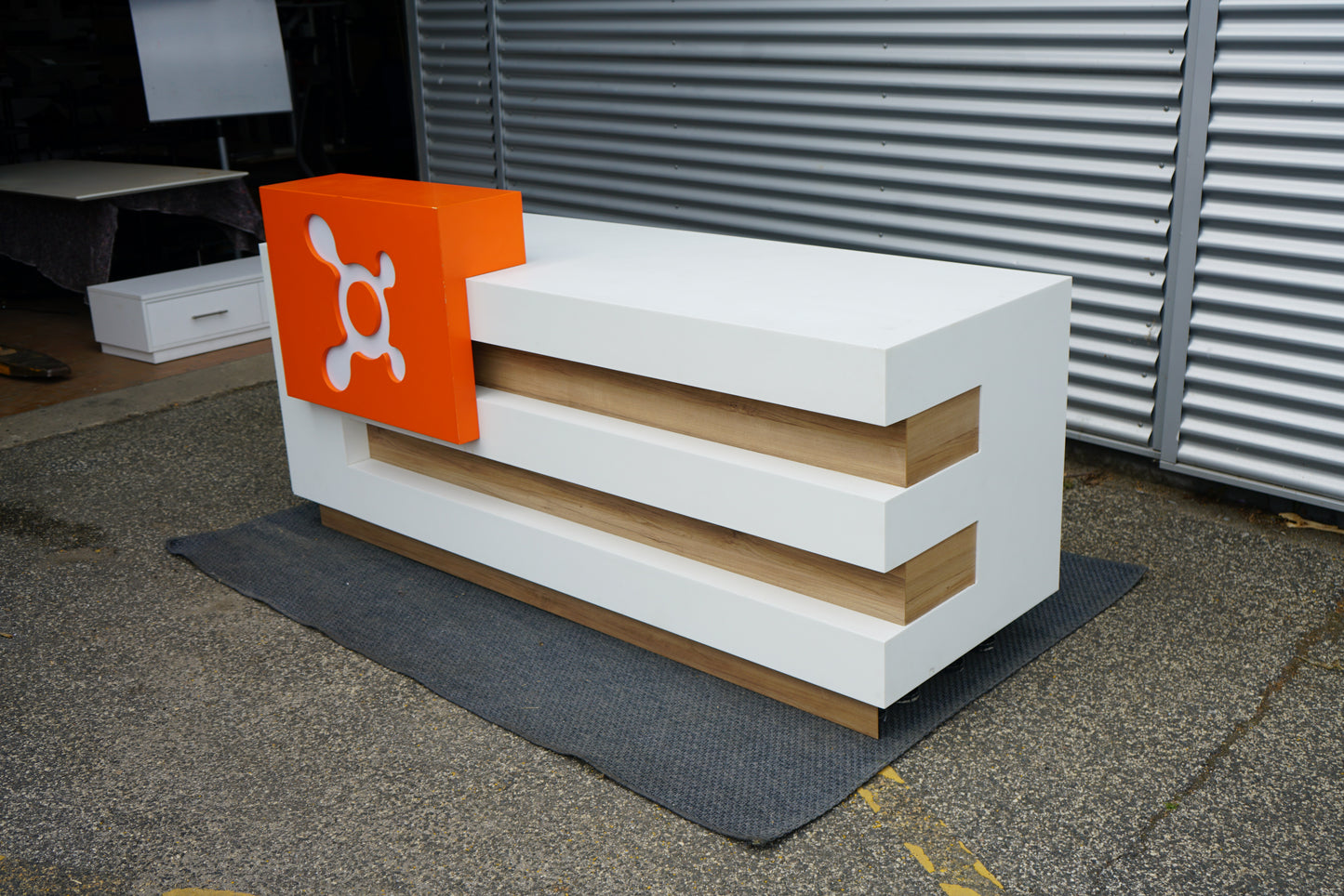 Receptionsskranke skråt fra venstre side med moderne design i hvid og træ.