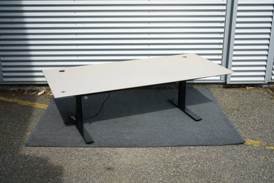 Rumas hæve-sænkebord 200x90 i beige linoleum med sort stel set fra skrå vinkel