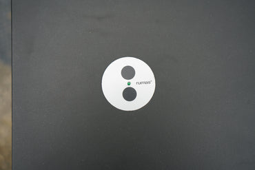 Detalje af Rumas logo på sort linoleum hæve-sænkebord