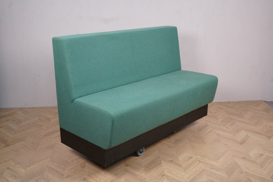 Rumas lounge-sofa i lysegrøn polstring med ryglæn set forfra.