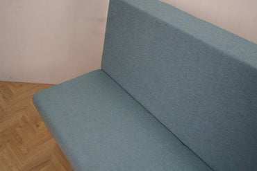 Rumas lounge i lyst stof med sort base set fra siden.