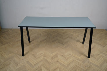 Rumas skrivebord 150x65 cm i grå med sorte ben set forfra.