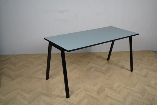 Rumas skrivebord 150x65 cm med grå bordplade og sorte ben set fra skrå vinkel.