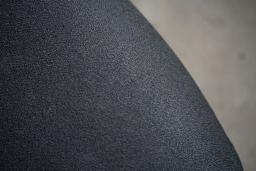 Close-up af sort polstring og detaljerne på Savo Eos kontorstol med gummibanehjul.