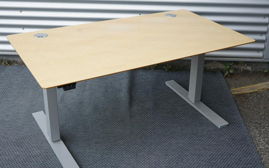 Scanoffice hæve-sænkebord 140x80 i ahornfiner med gråt understel, kabelbakke og kabelgennemføring, set fra skrå vinkel.