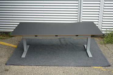 Scanoffice hæve-sænkebord i sort linoleum med trækant og gråt stel – set bagfra med kabelbakke