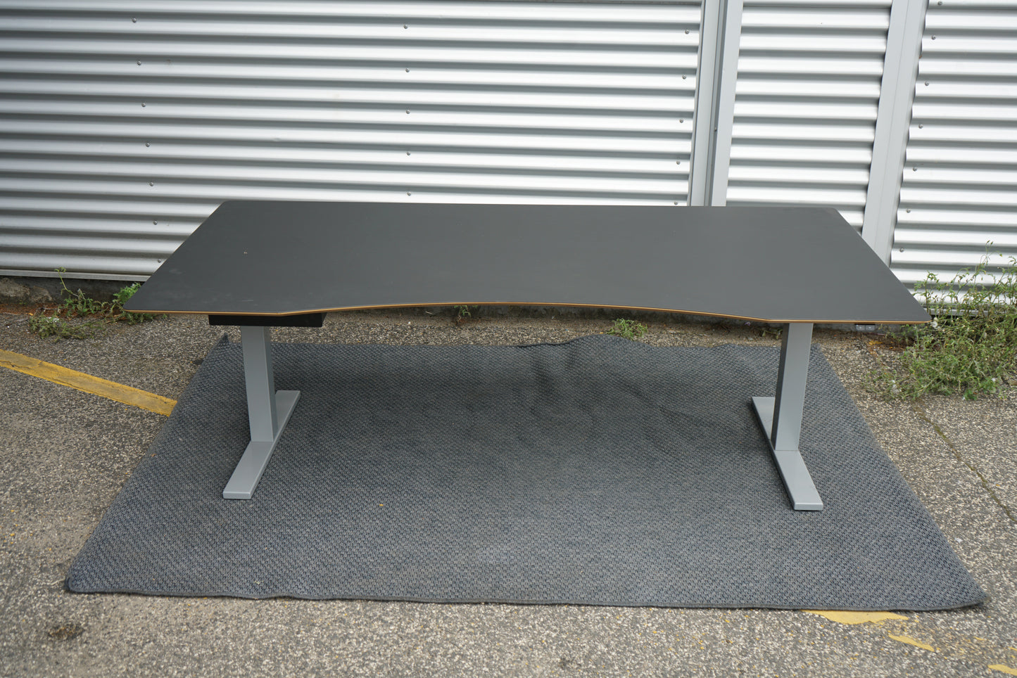 Frontbillede af Scanoffice hæve-sænkebord 200x100 cm med sort linoleum, trækant og buet front