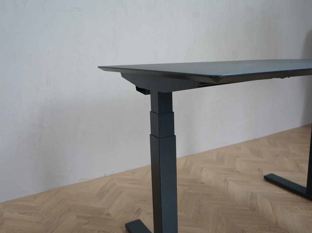 Nærbillede af Scanoffice hæve-sænkebord med sort linoleumsplade og affasede kanter. Detalje af bordpladens overflade og finish.