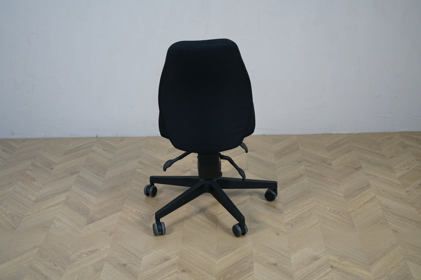 Scanoffice sort kontorstol set bagfra med fuldpolstret ryg og justeringshåndtag.