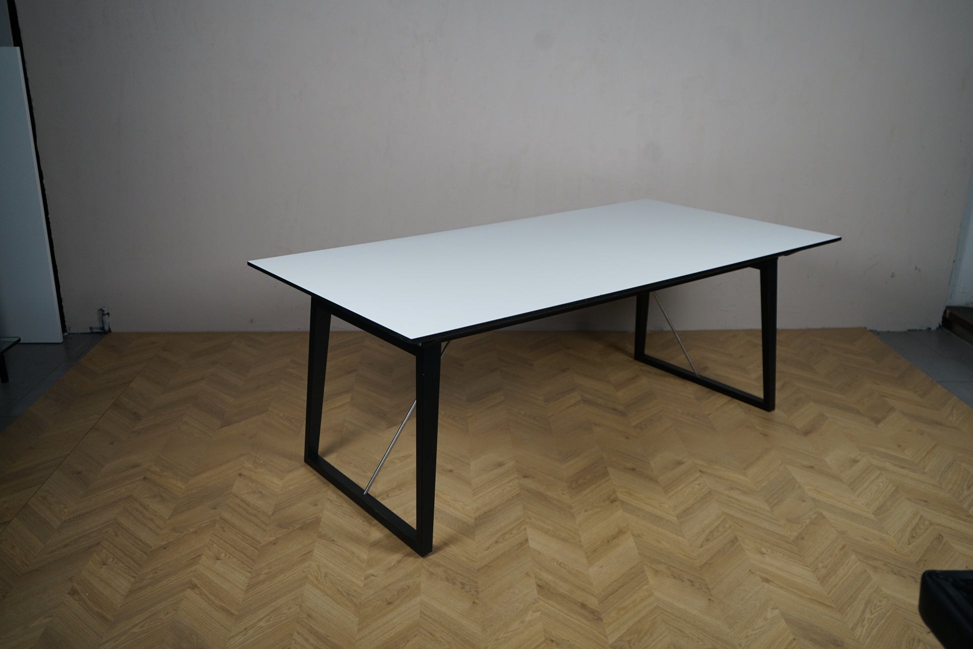 Skovby konferencebord i hvid laminat med sort stel set skråt fra højre, udtræksfunktion 200-300 cm.