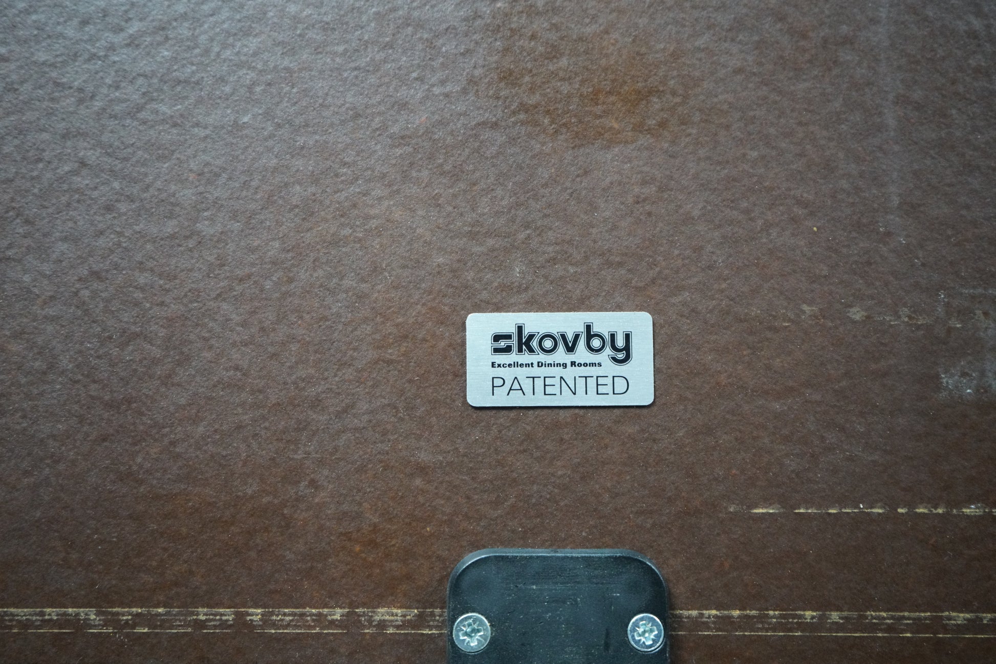 Skovby møbler logo og mærke fotograferet i close-up på konferencebord med udtræk.