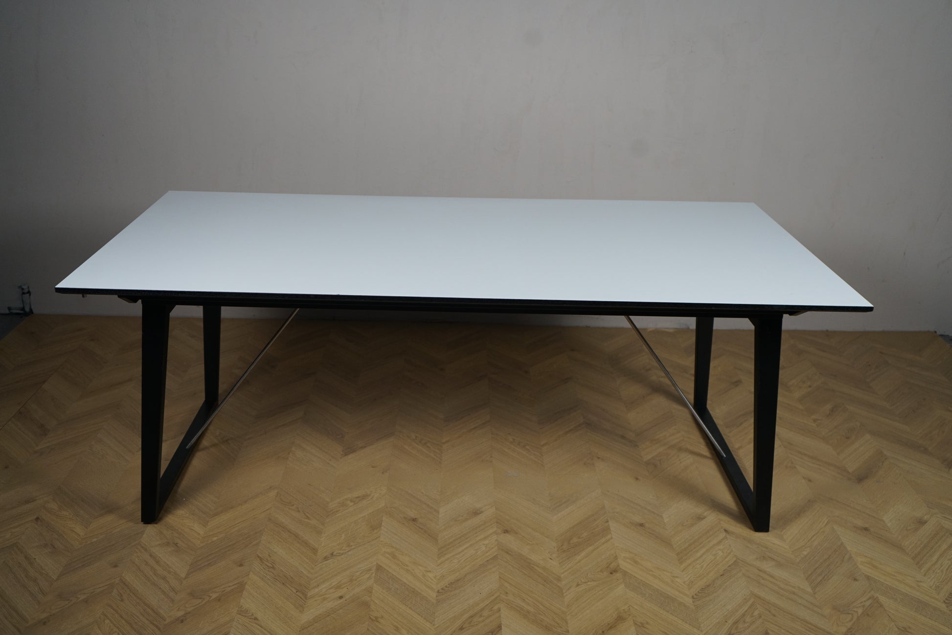 Skovby mødebord i hvid laminat med sort stel fotograferet fra fronten, udtræksbord til møder og spisestue.