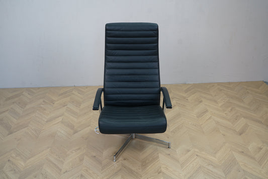 Sort læder loungestol med høj ryg, armlæn og drejefod set forfra