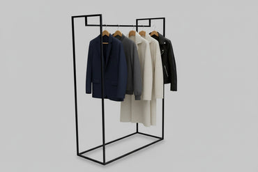 Sort tøjstativ i pulverlakeret stål med ophængt tøj i moderne interiør