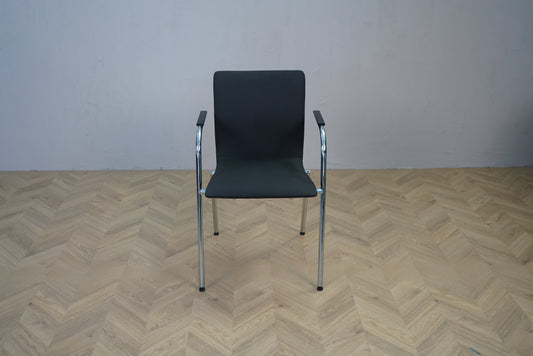 Stabelbar konferencestol i mørkegrå stof med armlæn og krom stel set forfra