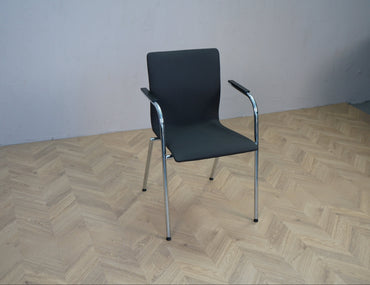 Stabelbar konferencestol i mørkegrå stof med armlæn og krom stel set skråt forfra