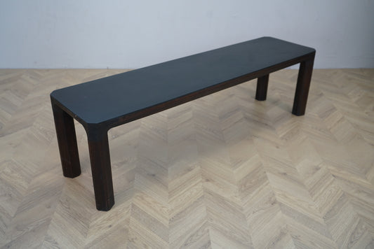 Moderne træbænk med sort sæde i minimalistisk design – set fra skrå vinkel, 153x37x44 cm