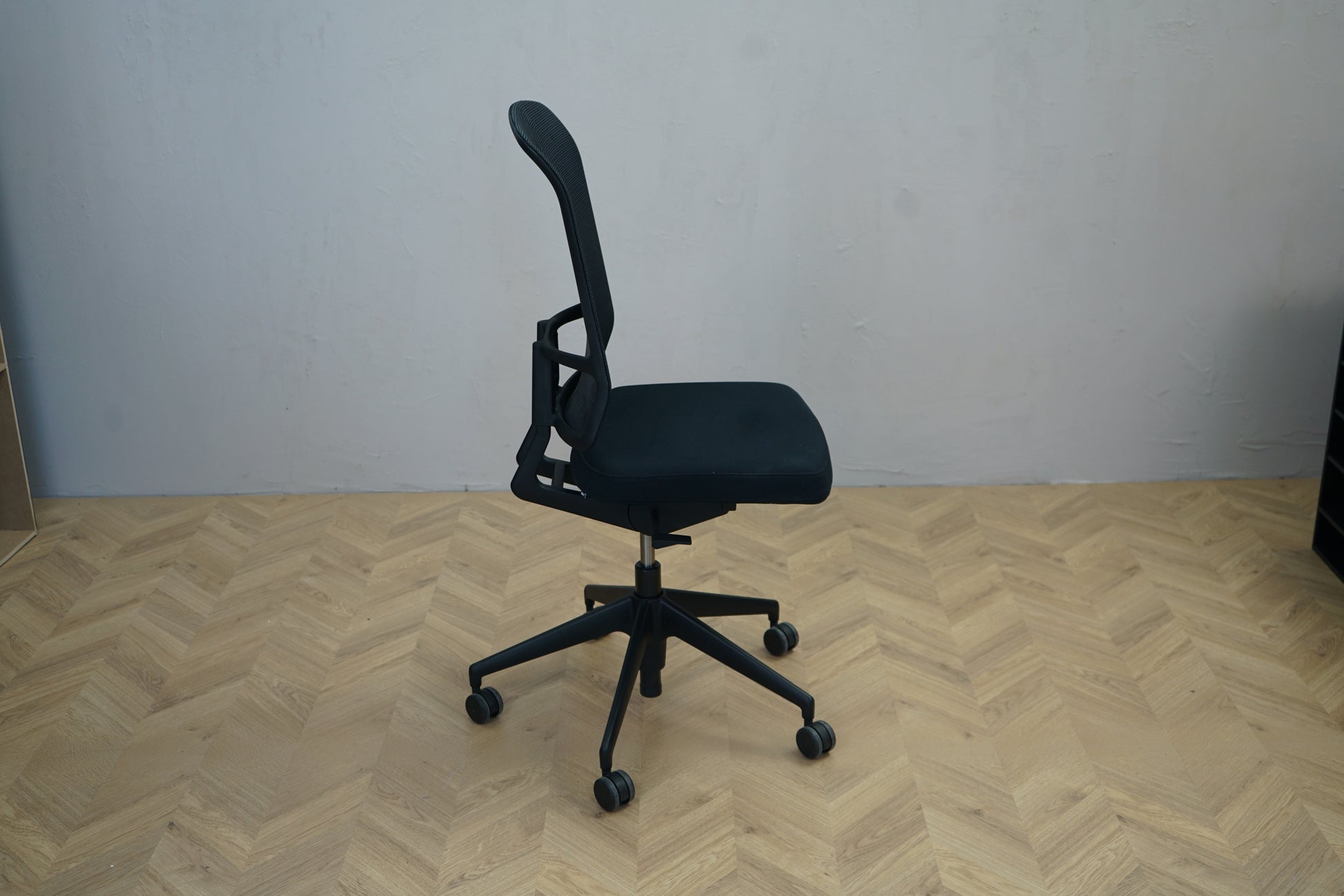 Vitra AM Chair ergonomisk kontorstol i sort med polstret sæde og mesh ryglæn – set fra siden.