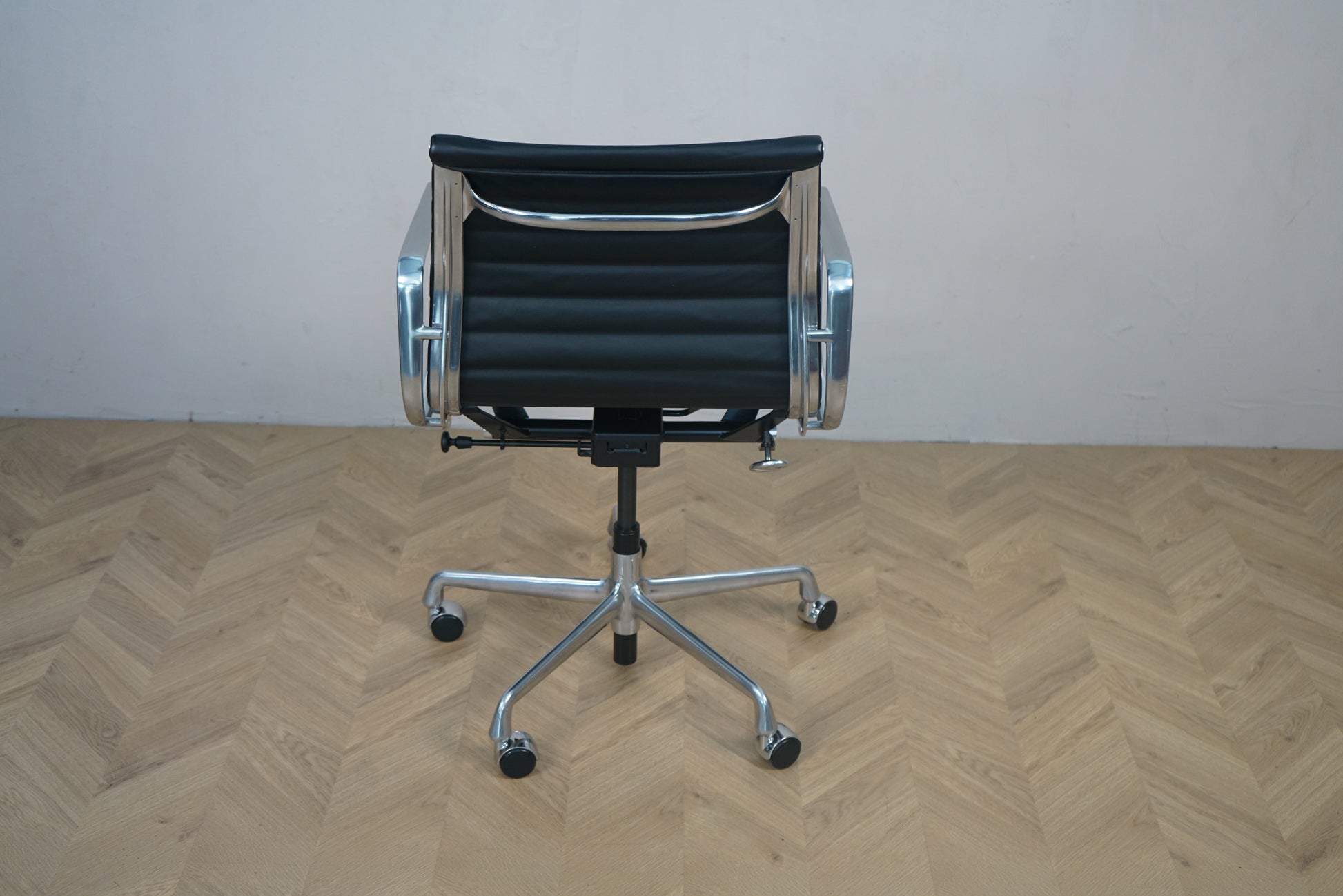 Vitra EA 117 kontorstol i sort læder med krom stel set bagfra – designklassiker fra Charles & Ray Eames