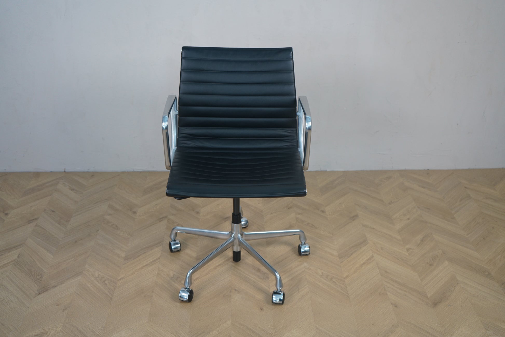 Vitra EA 117 kontorstol i sort læder med krom stel set forfra – design af Charles og Ray Eames