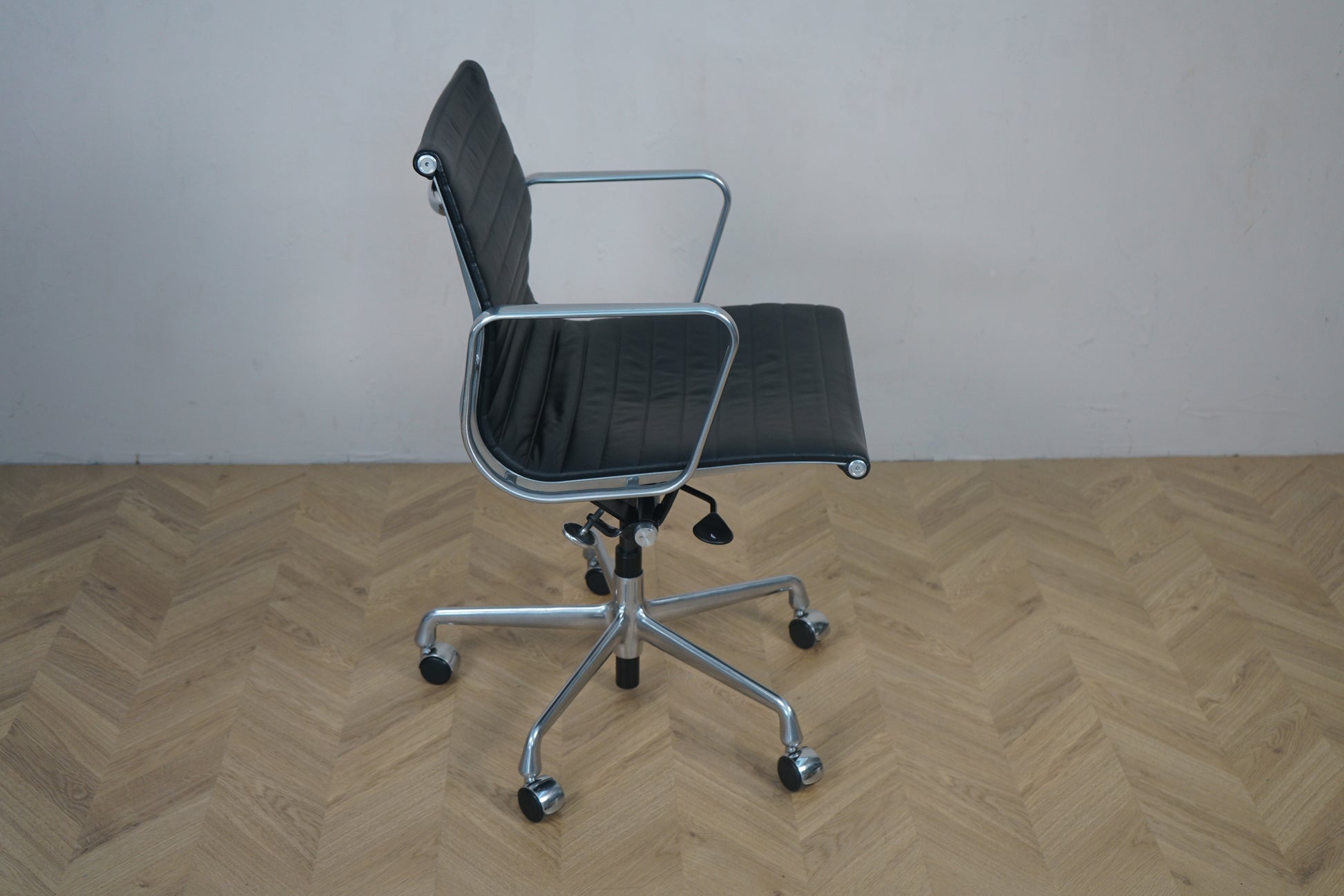 Vitra EA 117 kontorstol set fra siden – sort læder og krom base med vippefunktion