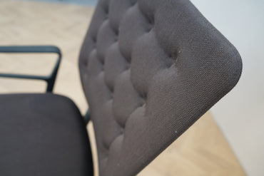 Nærbillede af Vitra ID Trim kontorstol med mørkegrå polstring og ergonomisk ryglæn.