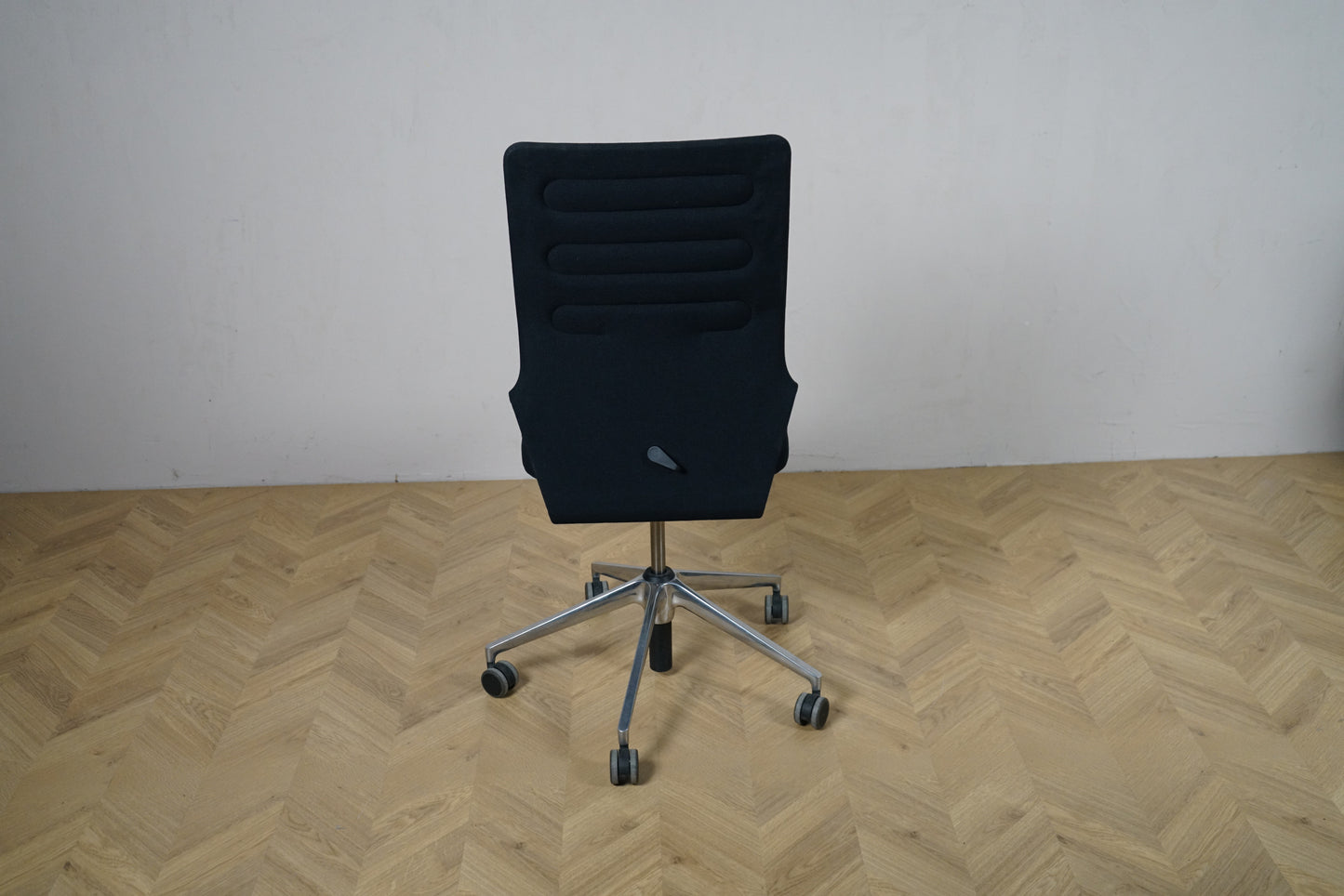 Vitra ID Trim kontorstol set bagfra med sort polstret ryglæn og slank ergonomisk design. Robust og velplejet kontorstol til kontorbrug.