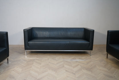 3 personers sort kunstlæder sofa set forfra med moderne design og armlæn