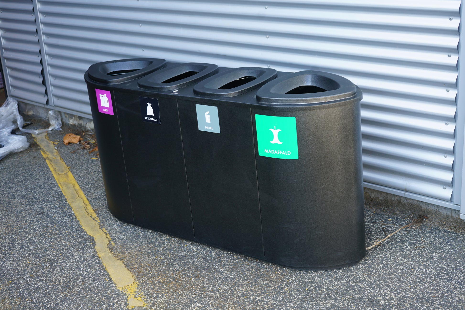 Affaldssortering med 4 rum i sort design set fra venstre skrå vinkel – sorteringsstation til plast, restaffald, metal og madaffald