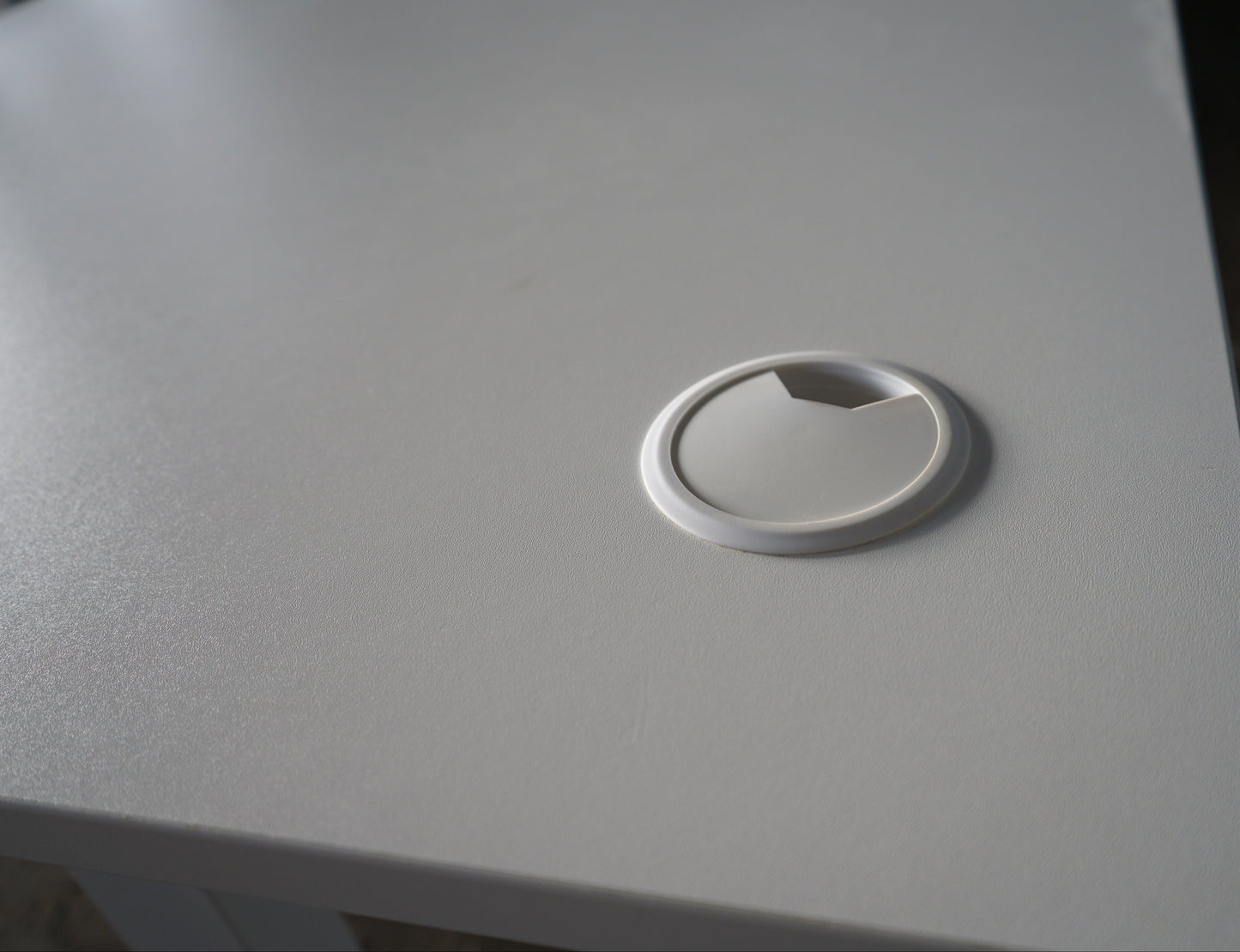 Kabelgennemføring på AJ Products hæve-sænkebord, der giver nem og organiseret kabelhåndtering.