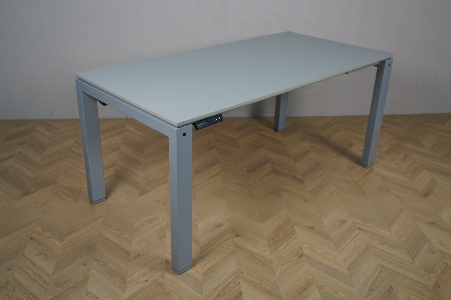 Arnehus hæve-sænkebord i grå set fra skrå vinkel, helt nyt 160x80 cm skrivebord med justerbart stel.