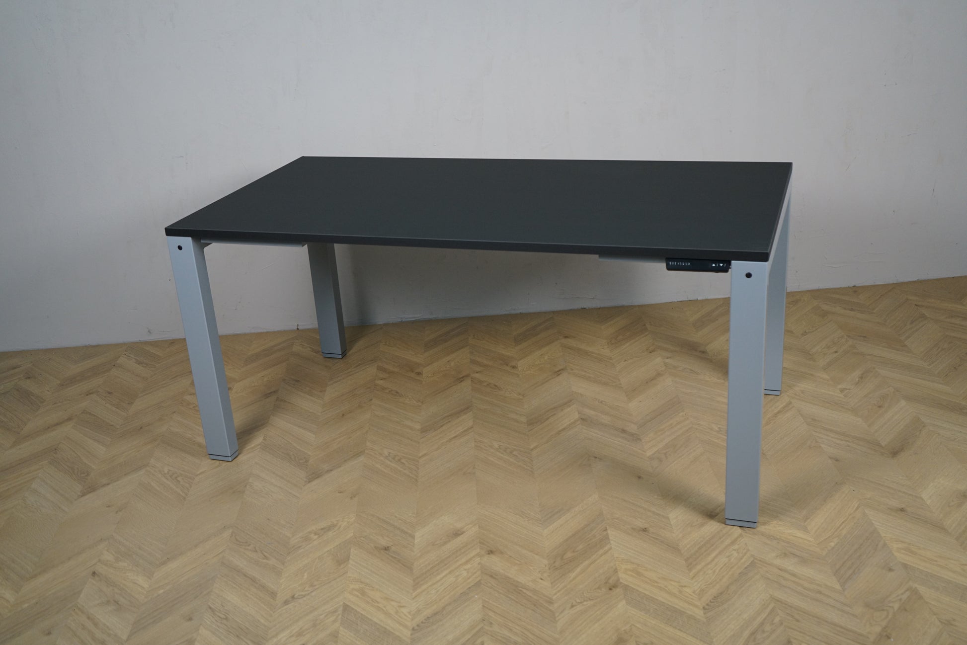 Arnehus hæve-sænkebord i sort set fra skrå vinkel, helt nyt 160x80 cm skrivebord med justerbart stel.