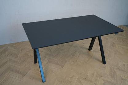Skråt billede af Arnehus hæve-sænkebord i sort linoleum med elegant design og funktionel højdejustering