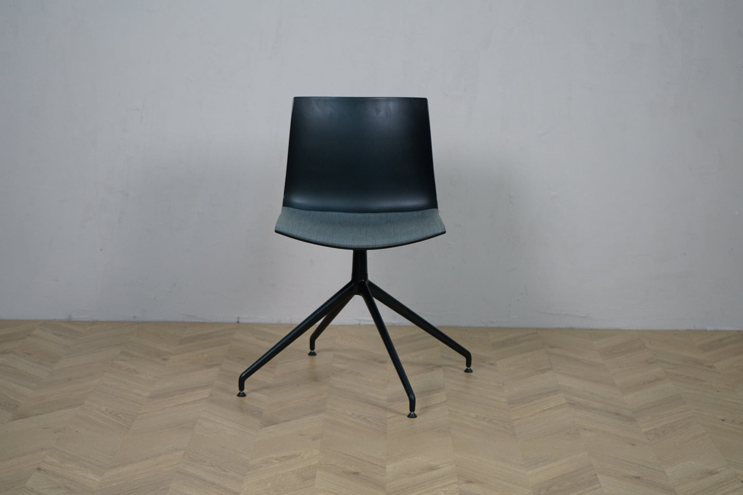 Arper Catifa 46 konferencestol set forfra med grå polstring og sort aluminium drejestel