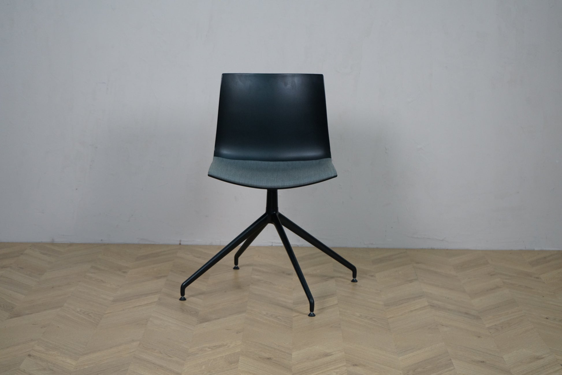 Arper Catifa 46 konferencestol set forfra med grå polstring og sort aluminium drejestel