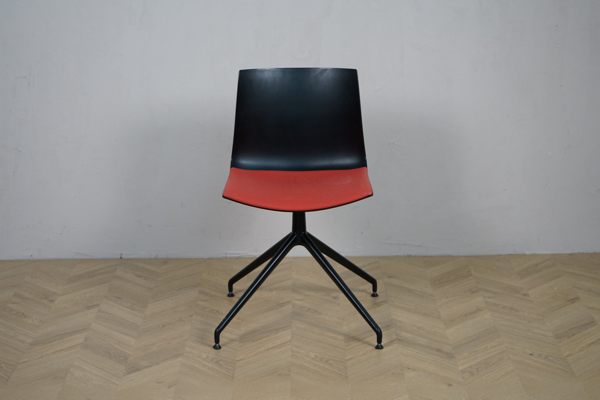 Arper Catifa 46 konferencestol set forfra med rød polstring og sort aluminium drejestel