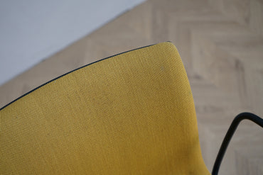 Close up af Arper Catifa 46 loungestolens gule polstring og sorte armlæn