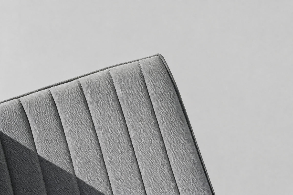 Close up af Arper Catifa 53 designerstol med grå kanalpolstring og kromstel