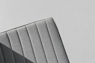 Close up af Arper Catifa 53 designerstol med grå kanalpolstring og kromstel