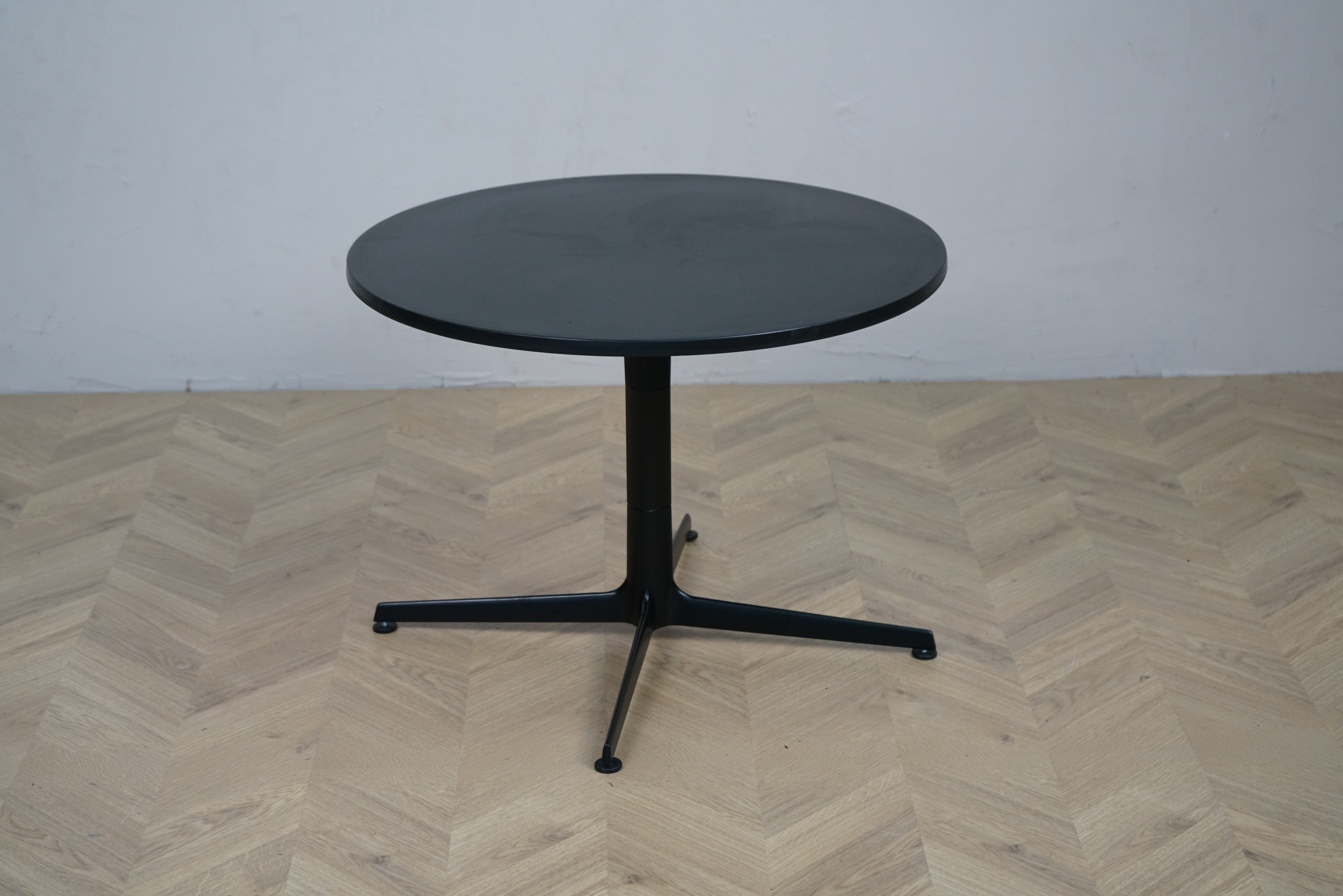 Arper rundt sofabord med sort bordplade og sort firpasfod set forfra