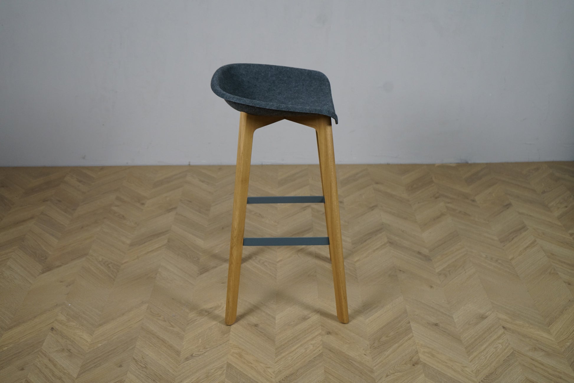 Moderne barstol med gråt buet sæde og egetræsben – set fra siden, siddehøjde 74 cm