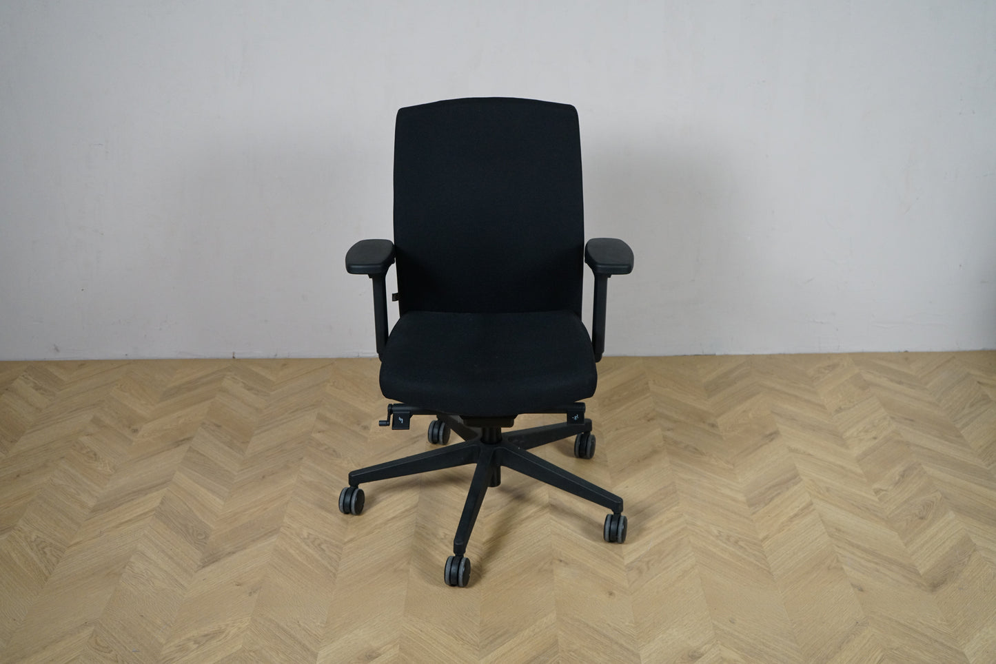 BE sort kontorstol set forfra med armlæn og polstret sæde